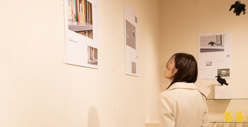 壁面の展示パネルを見る来場者