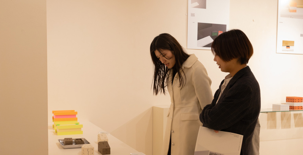 作品を見ながら話す来場者